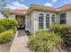 Welcoming front entrance featuring arched windows, a decorative glass block, and vibrant landscaping at 177 Treviso Ct, North Venice, FL 34275