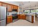 Well-equipped kitchen features wood cabinets, granite counters, and stainless steel appliances with seamless access to the dining area at 177 Treviso Ct, North Venice, FL 34275