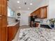 Charming kitchen with granite countertops, wood cabinets, and modern stainless steel appliances at 177 Treviso Ct, North Venice, FL 34275