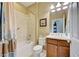 Well-lit bathroom featuring a combination bathtub and shower, tiled walls, a vanity, and coordinating accessories at 19124 Mangieri St, Venice, FL 34293