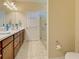 Bathroom with a glass door shower, toilet, and wooden vanity at 19124 Mangieri St, Venice, FL 34293