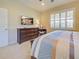 This bedroom features an ensuite bathroom, plantation shutters, carpeted floors and dark wooden furniture at 19124 Mangieri St, Venice, FL 34293