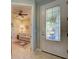 Welcoming foyer with tile flooring, glass door, and a view into a living room with comfortable seating at 19124 Mangieri St, Venice, FL 34293