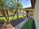 Cozy covered porch with brick flooring, seating area, and lush landscaping, offering a relaxing outdoor space at 19124 Mangieri St, Venice, FL 34293