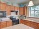 This kitchen features wooden cabinetry, tile backsplash, granite countertops and stainless steel appliances at 19124 Mangieri St, Venice, FL 34293