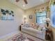 Cozy living room featuring a comfortable sofa, palm-themed decor, and ample natural light at 19124 Mangieri St, Venice, FL 34293