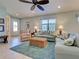 Comfortable living room featuring plush seating, a woven ottoman, and plenty of natural light at 19124 Mangieri St, Venice, FL 34293