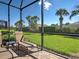 This screened patio features brick flooring and a comfortable lounge chair for outdoor relaxation at 19124 Mangieri St, Venice, FL 34293