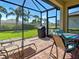 The screened patio includes comfortable seating, a ceiling fan, and a lovely view of the yard at 19124 Mangieri St, Venice, FL 34293