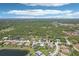 A neighborhood view featuring houses with lush landscapes, adjacent to wooded areas and lakes at 19893 Cobblestone Cir, Venice, FL 34292