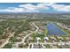 Expansive aerial view of the community including homes and a scenic lake at 19893 Cobblestone Cir, Venice, FL 34292