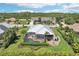 Aerial view of backyard pool, firepit, screened-in lanai, lush landscaping, and well-manicured yard at 19893 Cobblestone Cir, Venice, FL 34292