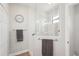 Modern bathroom with glass enclosed shower, neutral tile, and convenient towel racks at 19893 Cobblestone Cir, Venice, FL 34292