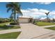 Beautiful single-story home showcases a well-maintained lawn, tall palm trees, and an expansive driveway with a two-car garage at 19893 Cobblestone Cir, Venice, FL 34292