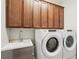 Well-equipped laundry room with Whirlpool washer/dryer and ample cabinet space above the sink at 19893 Cobblestone Cir, Venice, FL 34292