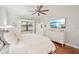 Comfortable main bedroom with hardwood floors, a ceiling fan, and a television at 19893 Cobblestone Cir, Venice, FL 34292