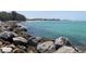 Tranquil ocean view with large rocks lining the shore, showcasing waterfront scenery and clear blue waters at 19893 Cobblestone Cir, Venice, FL 34292