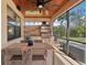 A covered outdoor kitchen features a built-in grill, mini-fridge, and seating area at 19893 Cobblestone Cir, Venice, FL 34292