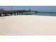 Expansive white sand beach with a long pier extending into the blue ocean under a sunny sky at 19893 Cobblestone Cir, Venice, FL 34292