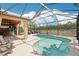 Beautiful pool area with screened enclosure, outdoor kitchen, and covered patio seating at 19893 Cobblestone Cir, Venice, FL 34292