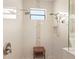 A stylish walk-in shower featuring elegant white tile, a pebble-stone accent and dual shower heads at 19893 Cobblestone Cir, Venice, FL 34292