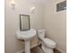 Powder room featuring pedestal sink, mirror, and toilet at 200 Sierra S St, Nokomis, FL 34275