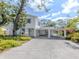 Bright exterior of a two-story home featuring blue shutters and mature landscaping at 200 Sierra S St, Nokomis, FL 34275