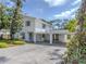 Bright exterior of a two-story home featuring blue shutters and mature landscaping at 200 Sierra S St, Nokomis, FL 34275