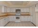 Kitchen has butcher block counters, white cabinets and appliances, and tile flooring at 200 Sierra S St, Nokomis, FL 34275