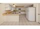 Kitchen has a bar counter and white appliances, cabinets and backsplash at 200 Sierra S St, Nokomis, FL 34275