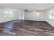 Bright living room with ceiling fan, railing, two windows and wood-look floors at 200 Sierra S St, Nokomis, FL 34275