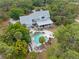 Aerial view of a luxurious pool and outdoor entertaining area surrounded by mature trees and lush greenery at 202 Laurel Oaks Rd, Nokomis, FL 34275