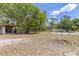 Large backyard with an outdoor kitchen, mature trees, and a resort-style pool with a waterfall feature at 202 Laurel Oaks Rd, Nokomis, FL 34275