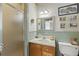Cozy bathroom features a step-in shower with glass door, soft green wainscoting, and charming decor at 202 Laurel Oaks Rd, Nokomis, FL 34275