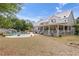 Expansive home featuring a charming porch, a lush yard, and a beautiful pool with a rock waterfall feature at 202 Laurel Oaks Rd, Nokomis, FL 34275