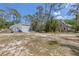 Spacious property featuring a metal building, two-story home, tractor, and lush greenery at 202 Laurel Oaks Rd, Nokomis, FL 34275