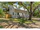 Charming two-story home with a metal roof, verdant lawn, and plenty of mature trees at 202 Laurel Oaks Rd, Nokomis, FL 34275