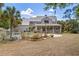 Expansive home featuring a charming porch, a lush yard, and a beautiful pool with a rock waterfall feature at 202 Laurel Oaks Rd, Nokomis, FL 34275