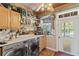 Bright laundry room with front-loading washer/dryer and cabinets with window view and exterior access at 202 Laurel Oaks Rd, Nokomis, FL 34275