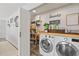Functional laundry room with modern appliances, folding counter, and built-in pantry storage at 202 Laurel Oaks Rd, Nokomis, FL 34275