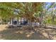 Outdoor kitchen featuring seating, counter space, and shade, all surrounded by lush greenery and mature trees at 202 Laurel Oaks Rd, Nokomis, FL 34275