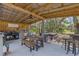The outdoor kitchen has a concrete floor and a wood roof, complete with a grill, sink, and dining table at 202 Laurel Oaks Rd, Nokomis, FL 34275