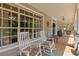 Inviting front porch with rocking chairs, wood flooring, and decorative elements creating a cozy atmosphere at 202 Laurel Oaks Rd, Nokomis, FL 34275