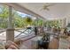 Inviting covered porch offers comfortable seating and serene views of the backyard and pool area at 202 Laurel Oaks Rd, Nokomis, FL 34275