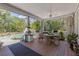 Covered porch with seating area overlooking a lush backyard with pool, waterfall, and mature trees at 202 Laurel Oaks Rd, Nokomis, FL 34275