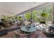 Spacious covered porch with dining table, seating, and views of the pool and landscaped backyard at 202 Laurel Oaks Rd, Nokomis, FL 34275