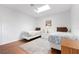 Bright bedroom with two twin beds, white walls, hardwood floors and a large window at 226 Southampton Ln # 257, Venice, FL 34293