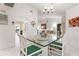 Open dining area showing white wicker chairs and table set under chandelier lighting at 226 Southampton Ln # 257, Venice, FL 34293