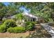 Well-maintained single-Gathering home with lush landscaping, mature trees, and a paved walkway at 226 Southampton Ln # 257, Venice, FL 34293