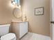Well-lit powder room featuring a toilet, sink, and framed artwork at 226 Southampton Ln # 257, Venice, FL 34293